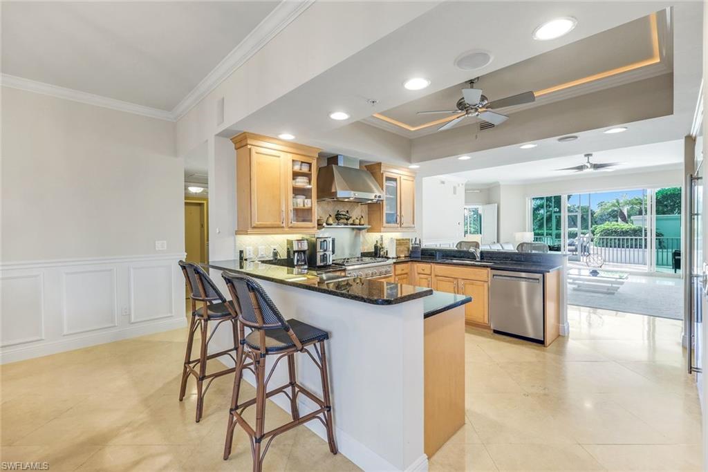 265 Indies Way, Unit T02 Naples, FL 34110 - Photo 11 of 38 a kitchen with stainless steel appliances granite countertop table chairs sink and cabinets