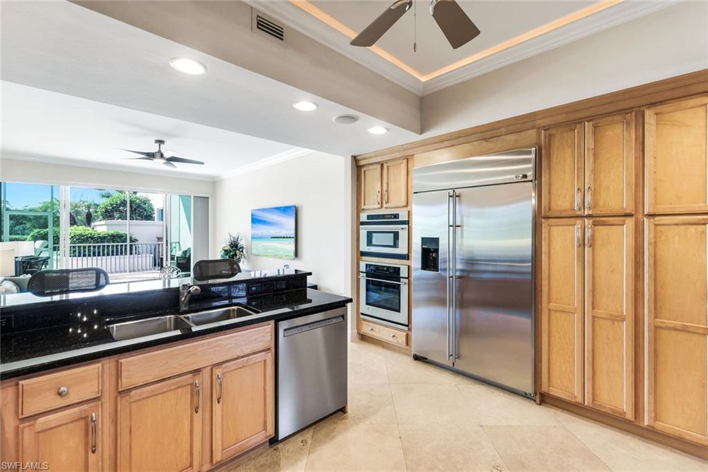 265 Indies Way, Unit T02 Naples, FL 34110 - Photo 13 of 38 a kitchen with granite countertop a refrigerator a sink a counter space and stainless steel appliances