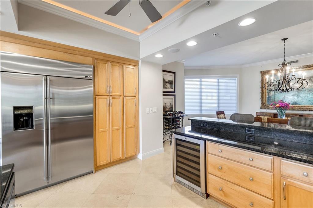 265 Indies Way, Unit T02 Naples, FL 34110 - Photo 14 of 38 a kitchen with granite countertop stainless steel appliances a sink and a refrigerator