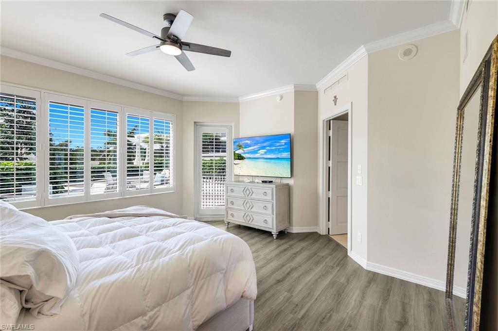 265 Indies Way, Unit T02 Naples, FL 34110 - Photo 15 of 38 a spacious bedroom with a bed and a dresser