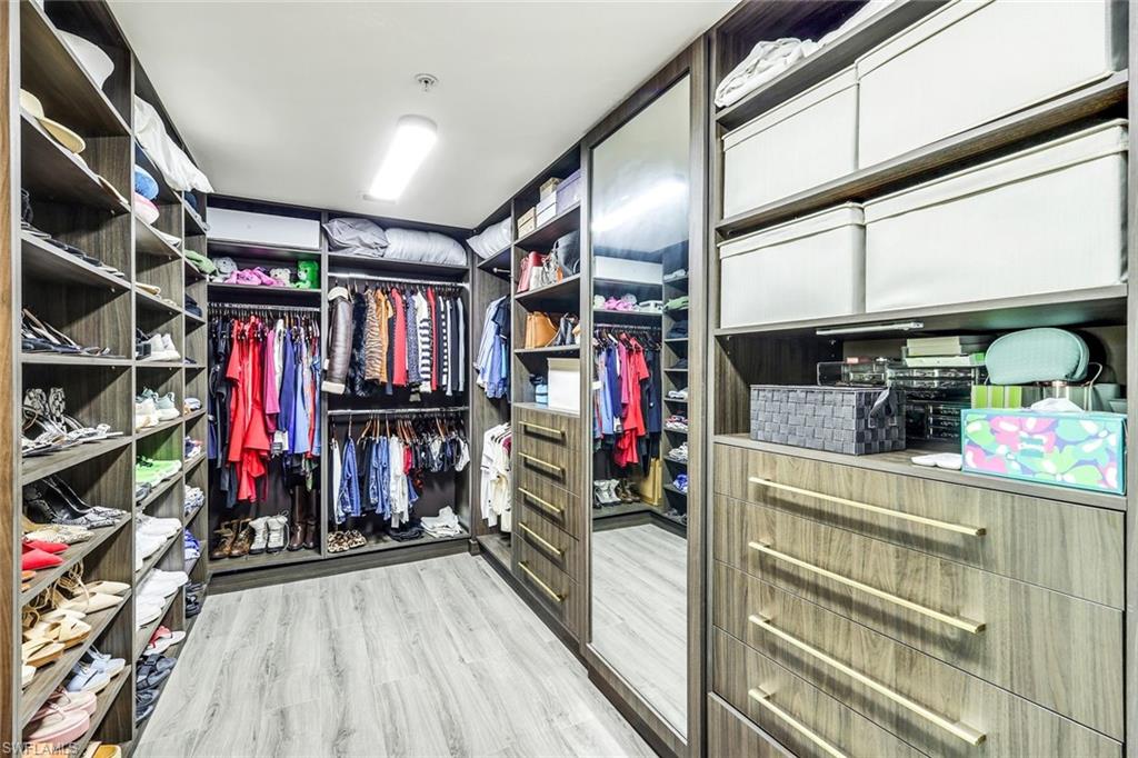 265 Indies Way, Unit T02 Naples, FL 34110 - Photo 17 of 38 a view of walk in closet with clothes and shoes
