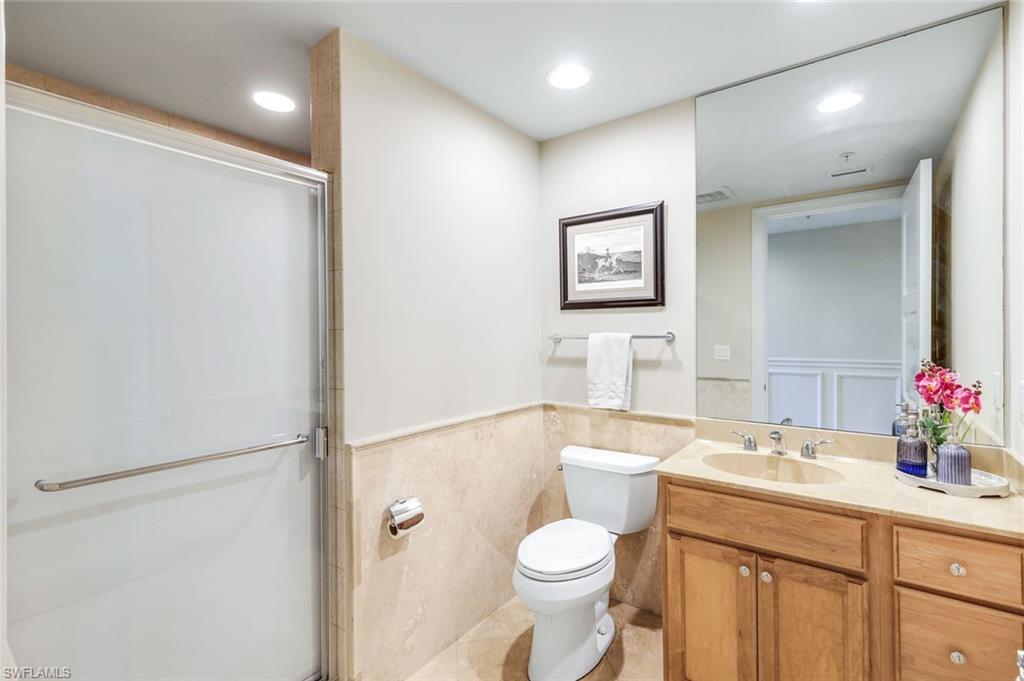 265 Indies Way, Unit T02 Naples, FL 34110 - Photo 24 of 38 a bathroom with a toilet a sink and a large mirror