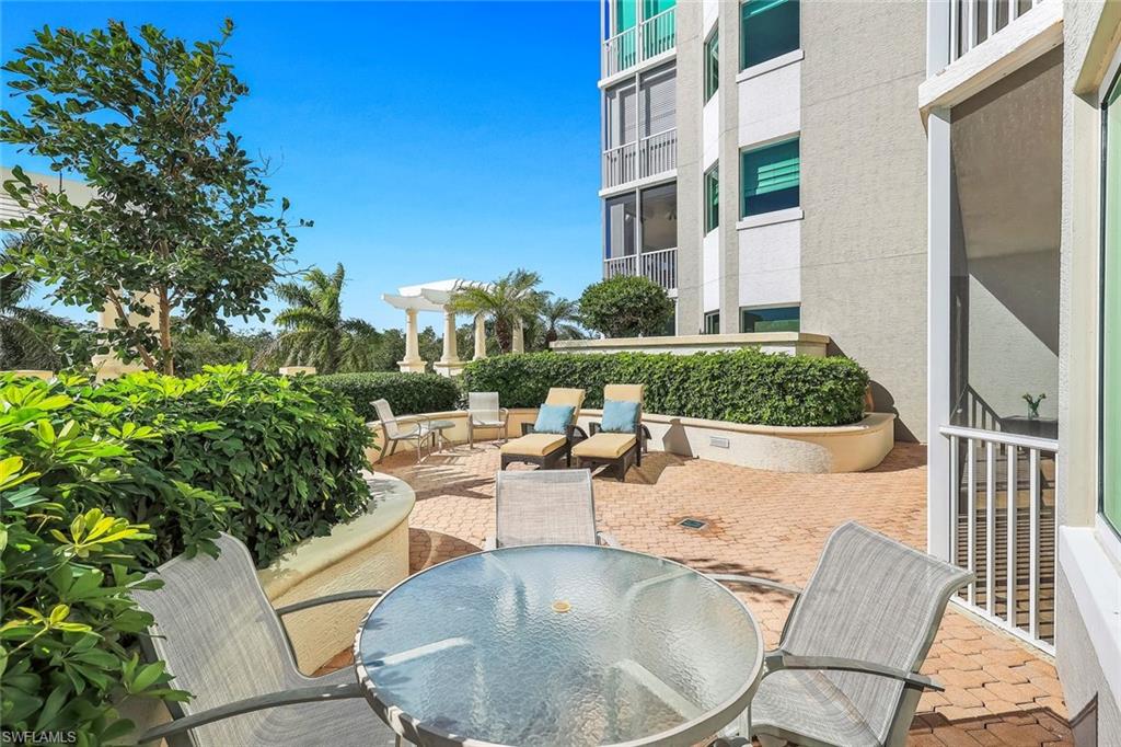 265 Indies Way, Unit T02 Naples, FL 34110 - Photo 29 of 38 a view of a patio with couches table and chairs and potted plants