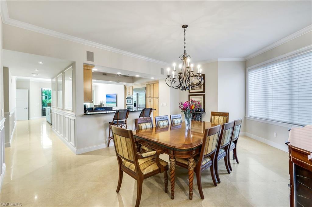 265 Indies Way, Unit T02 Naples, FL 34110 - Photo 9 of 38 a dining room with furniture a chandelier and kitchen view