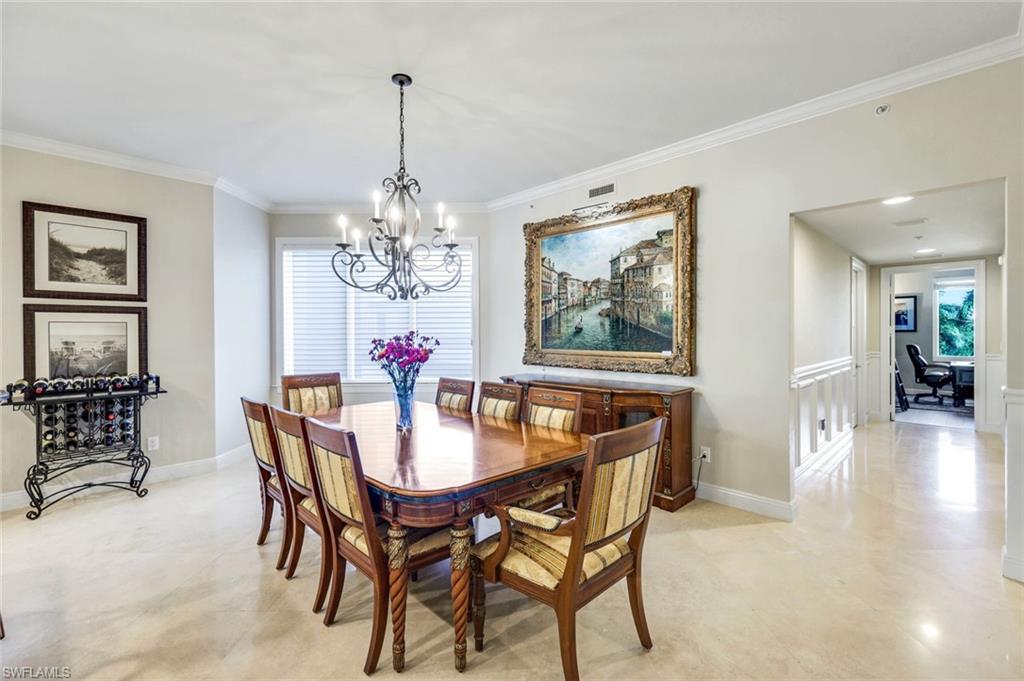 265 Indies Way, Unit T02 Naples, FL 34110 - Photo 10 of 38 a dining room with furniture a chandelier and wooden floor