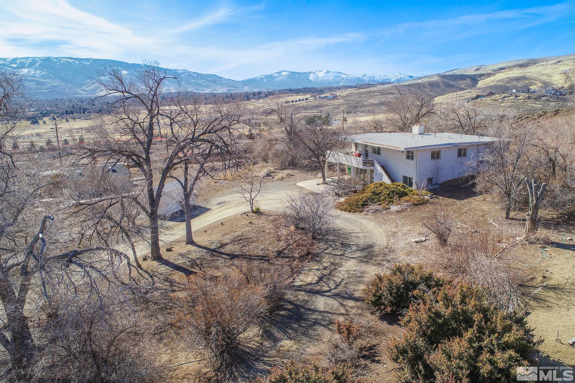 385 Greenstone Drive Reno, NV 89512 - Photo 3 of 34 a view of a dry yard with mountains in the background
