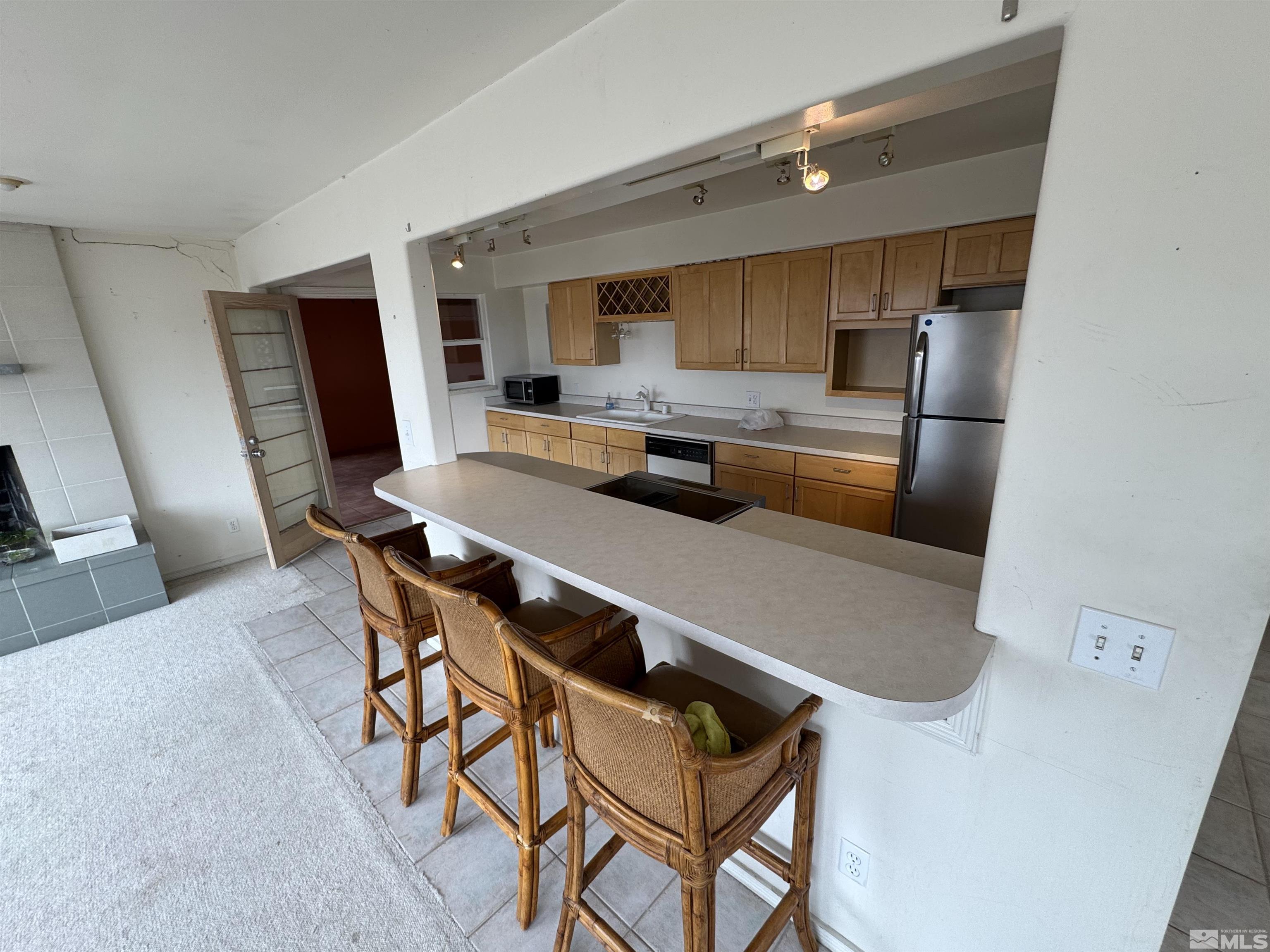 385 Greenstone Drive Reno, NV 89512 - Photo 8 of 34 a kitchen with stainless steel appliances a refrigerator a sink a stove a dining table and chairs