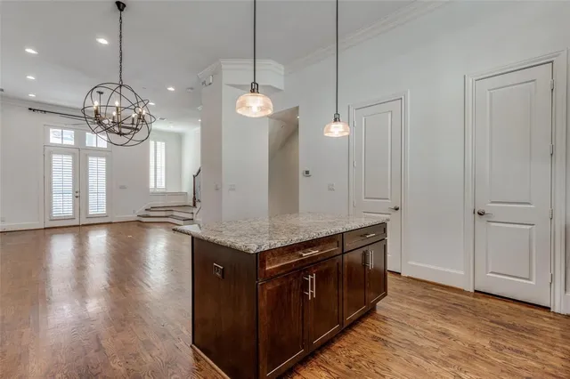 an open kitchen with granite countertop stove and wooden floor