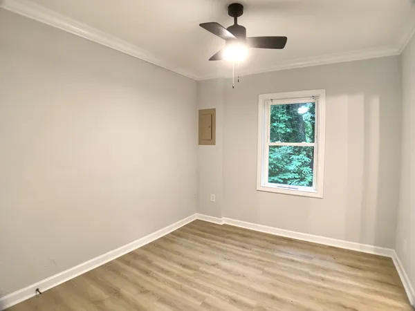 an empty room with a window and a ceiling fan