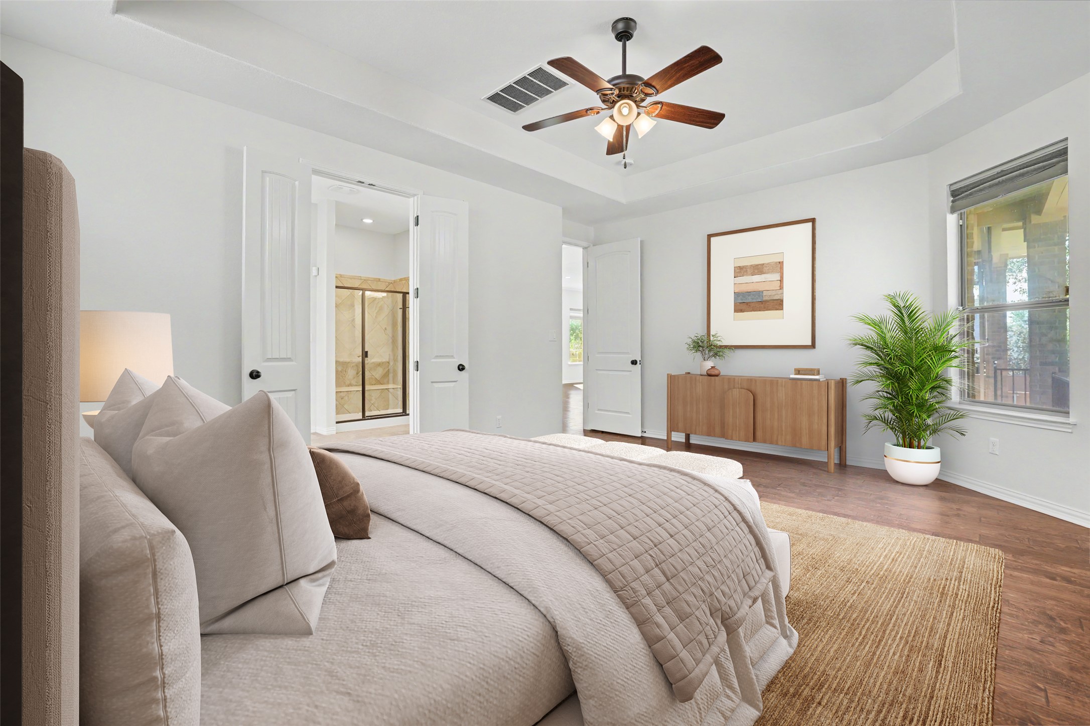 1020 Winding Way Drive Georgetown, TX 78628 - Photo 13 of 32 Bedroom with a raised ceiling, wood finished floors, connected bathroom, and ceiling fan