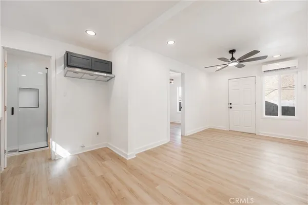 a view of a livingroom with a ceiling fan hardwood floor and a ceiling fan