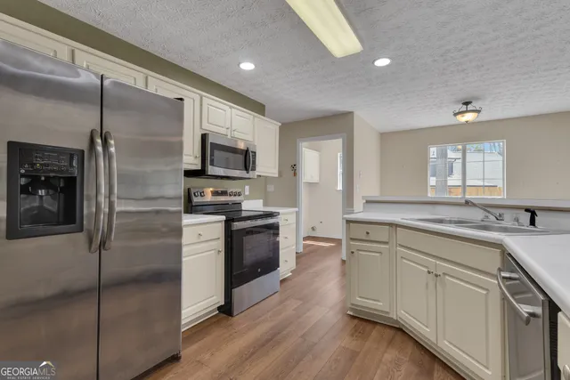a kitchen with white cabinets and sink