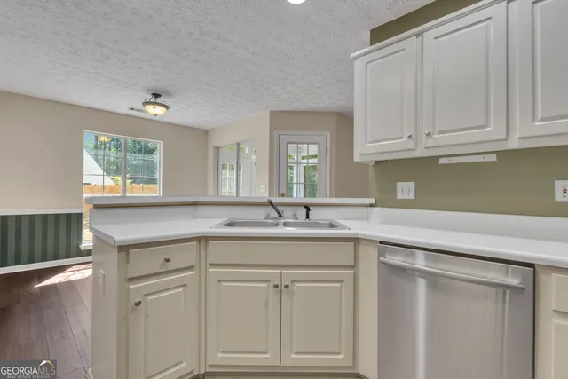 a kitchen with stainless steel appliances granite countertop a sink a stove a refrigerator and cabinets