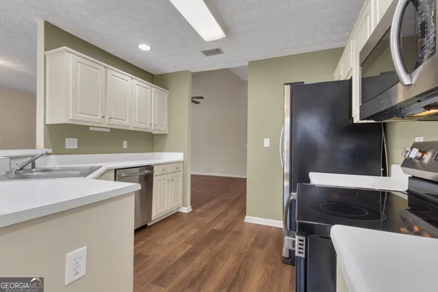 a kitchen with stainless steel appliances granite countertop a stove microwave and refrigerator