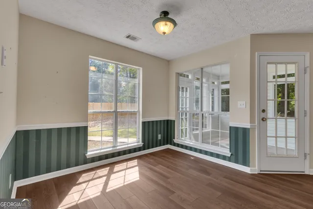 a view of a kitchen with a fridge and wooden floor
