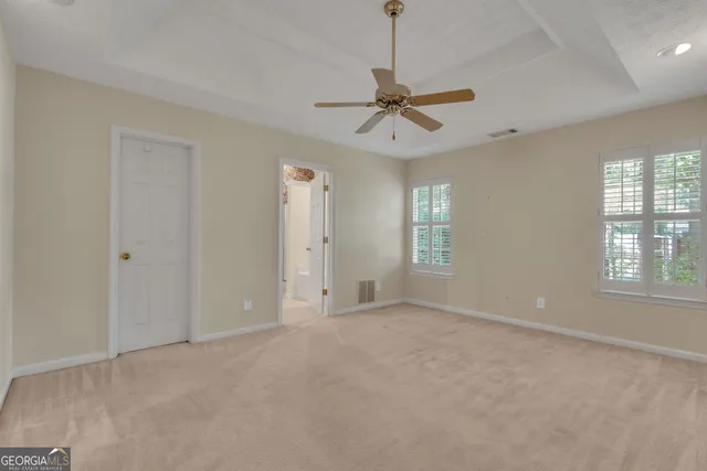 an empty room and chandelier fan in a room