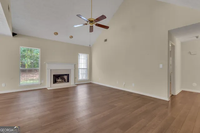 a view of an empty room with exposed radiator and fireplace