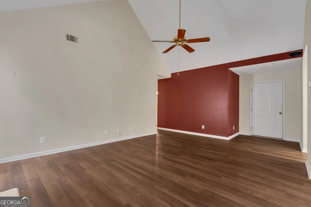 a kitchen with a refrigerator a sink cabinets and wooden floor