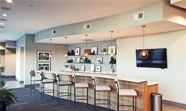 a kitchen with stainless steel appliances kitchen island granite countertop a dining table chairs and a refrigerator