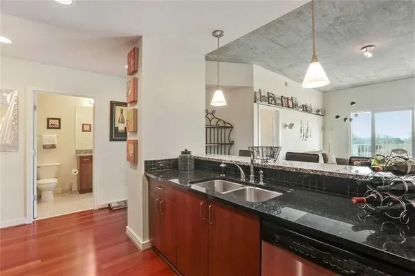 a kitchen with granite countertop a sink and a refrigerator
