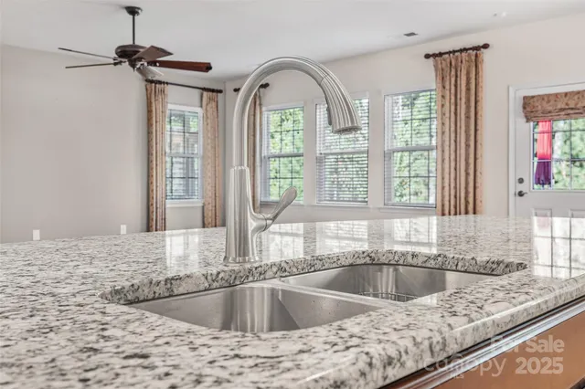 a view of a kitchen counter top a stove and wooden floor