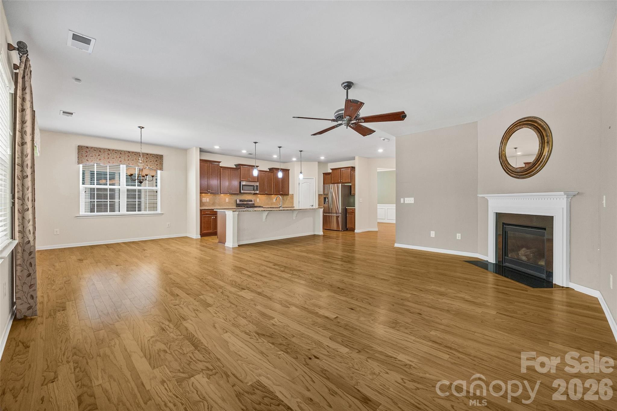 4201 Perth Road Fort Mill, SC 29707 - Photo 22 of 35 a view of a livingroom with a fireplace a ceiling fan and windows