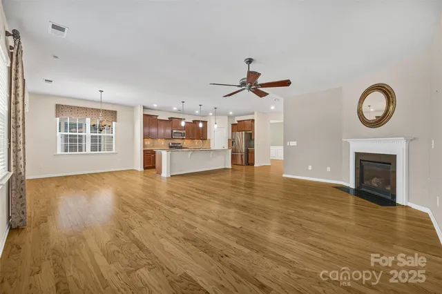 a view of empty room with wooden floor and fireplace