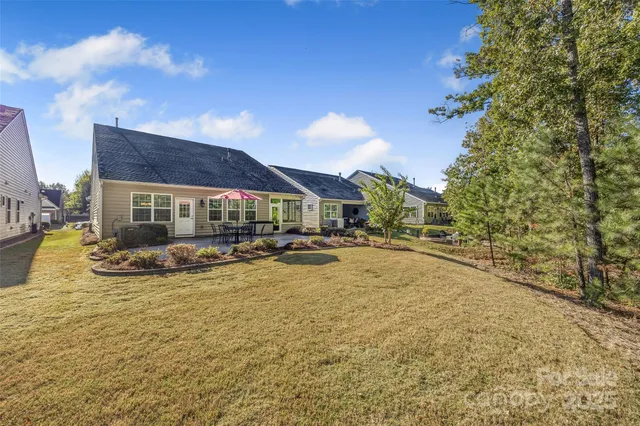 a view of swimming pool with outdoor seating and house in the background