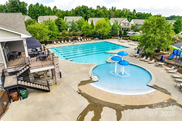 a view of a swimming pool with a patio and plants