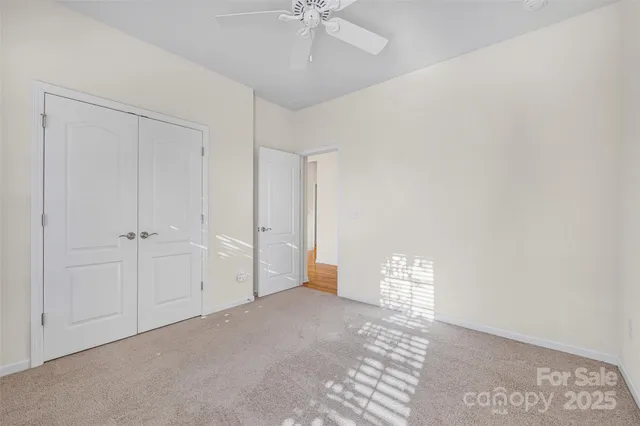 a view of an empty room with a ceiling fan