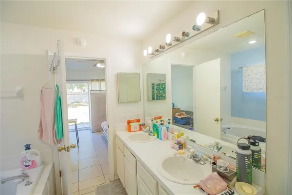 a bathroom with a sink vanity granite tub shower and a mirror
