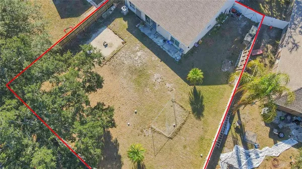 an aerial view of a house with a yard and tennis court