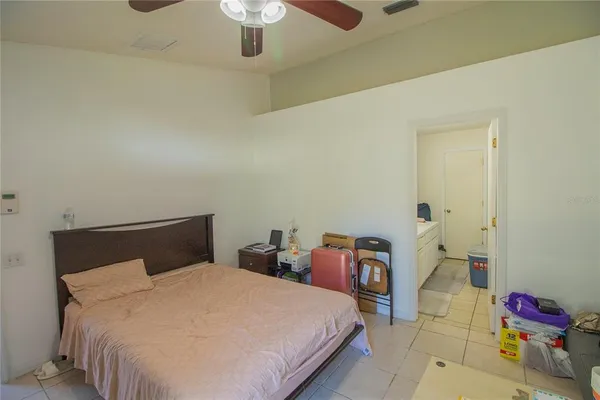 a bedroom with a bed and a chandelier fan