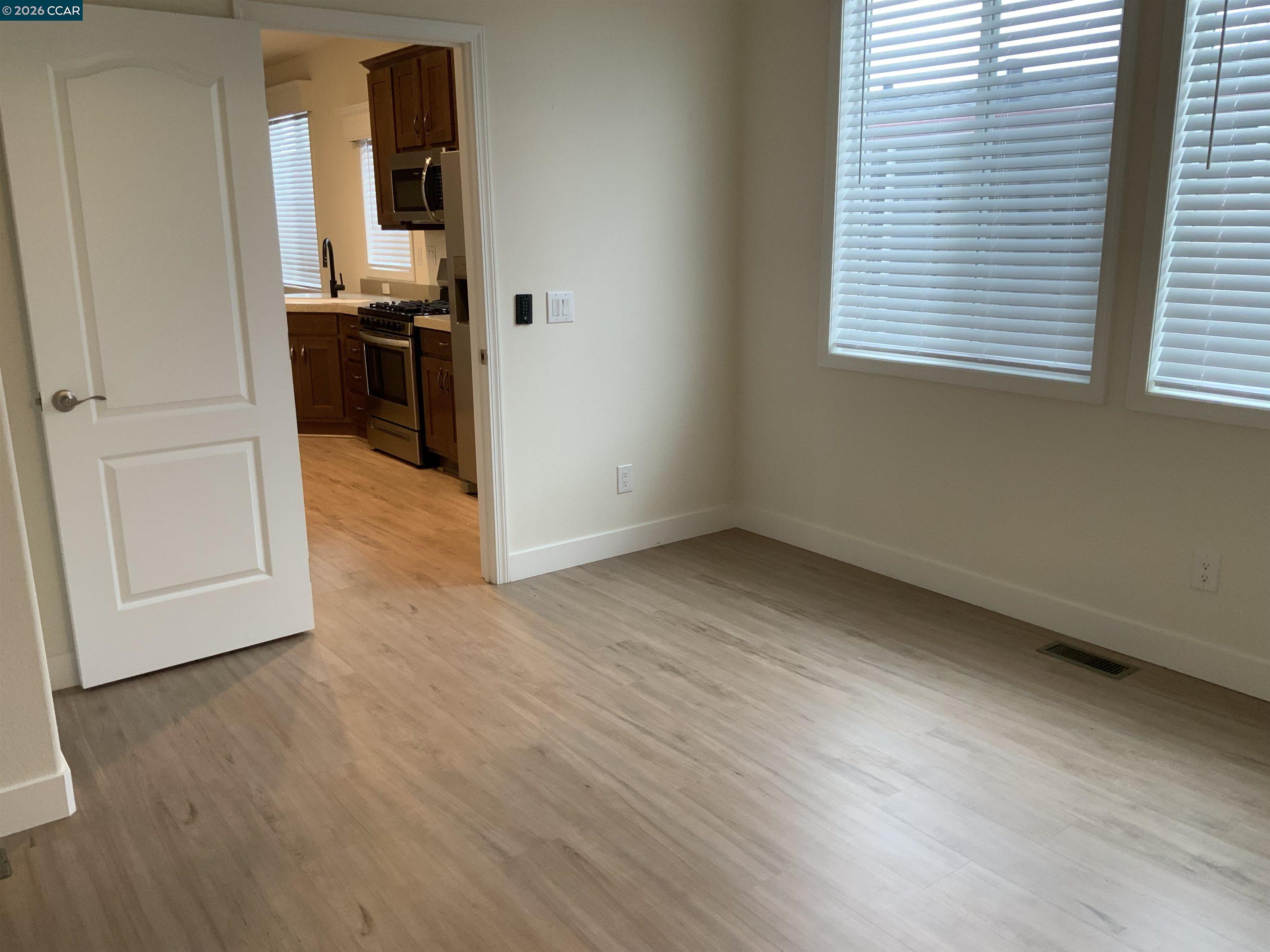 65 Pali Way Pittsburg, CA 94565 - Photo 13 of 32 an empty room with wooden floor cabinet and windows