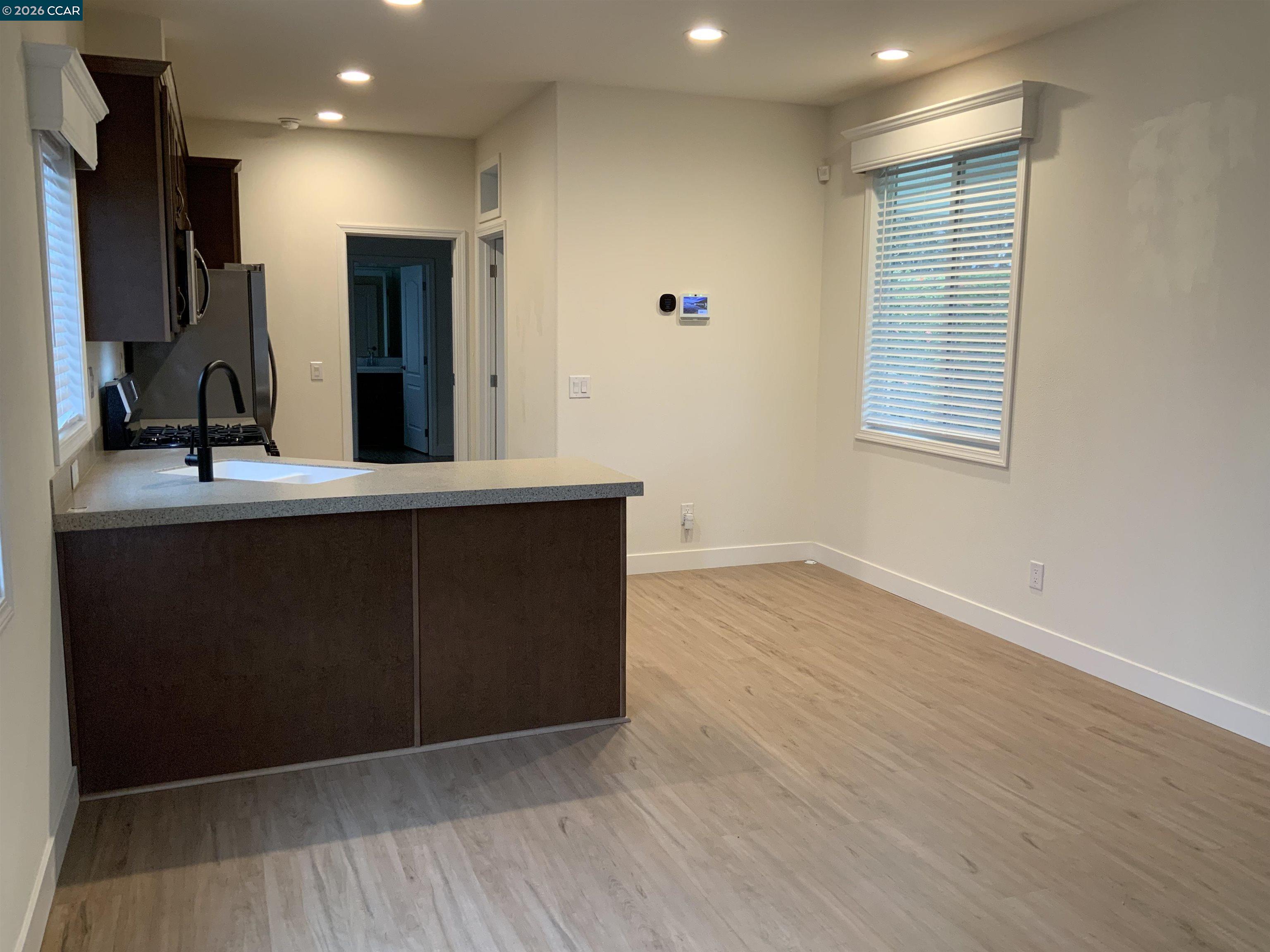 65 Pali Way Pittsburg, CA 94565 - Photo 3 of 32 a kitchen with kitchen island a sink wooden floor and a large window