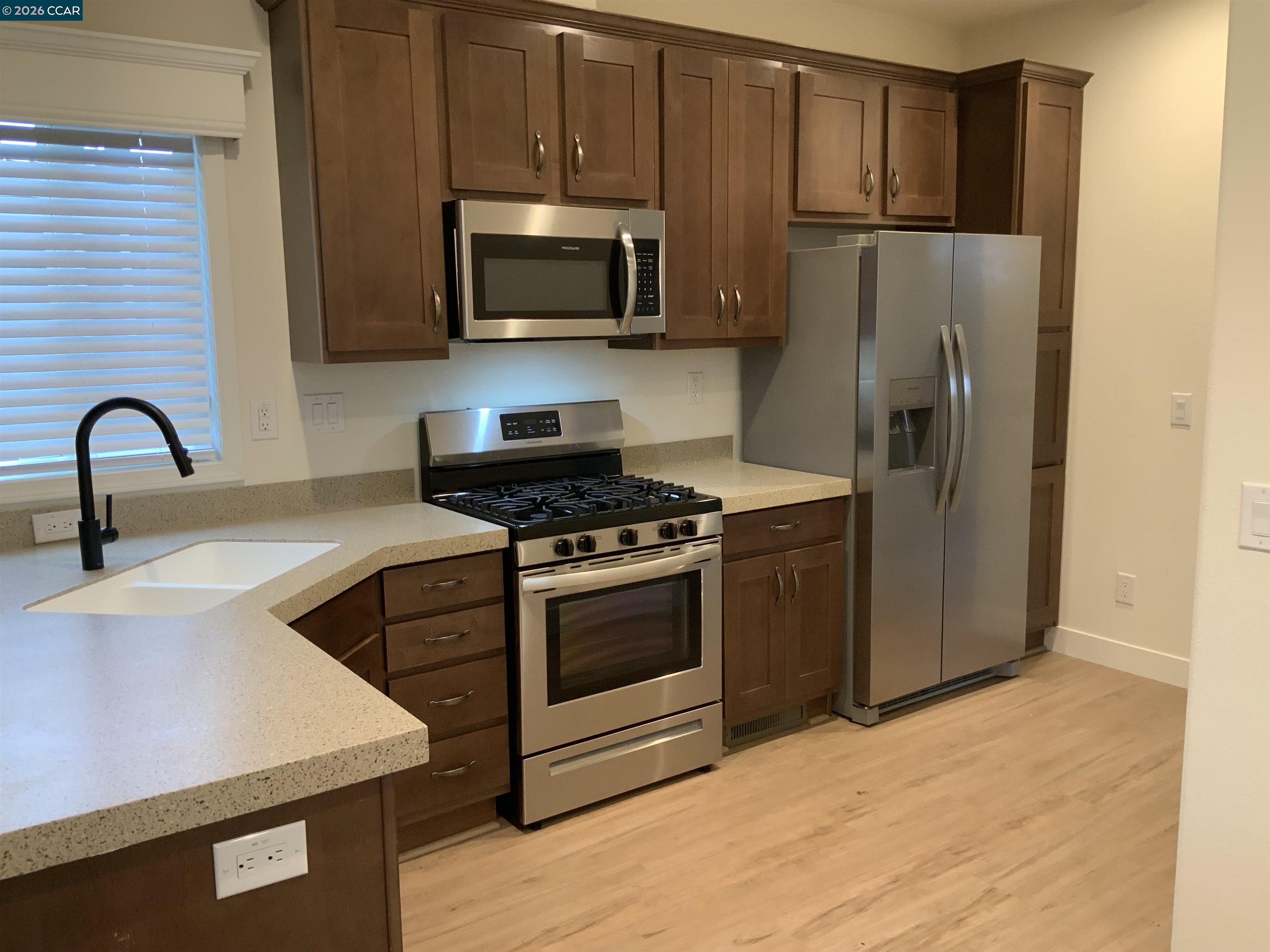 65 Pali Way Pittsburg, CA 94565 - Photo 5 of 32 a kitchen with stainless steel appliances kitchen island a stove a sink and a refrigerator