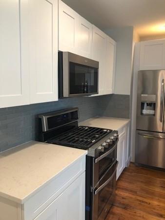 83 Dana Street Springfield, MA 01104 - Photo 10 of 20 a kitchen with granite countertop a stove and a refrigerator