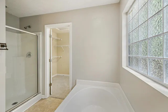 a bathroom with a tub a sink and a window
