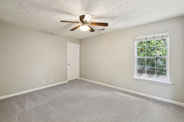 an empty room with chandelier fan