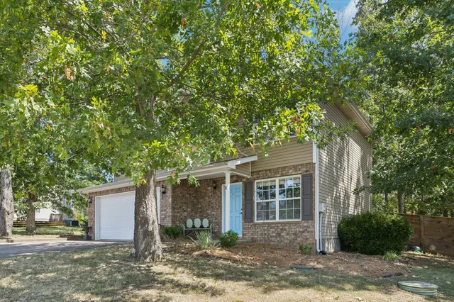 a view of a house with a tree in front of it