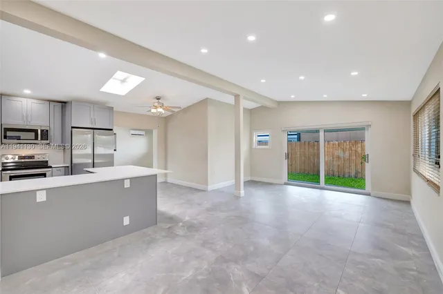 a large kitchen with stainless steel appliances a large counter top a stove and a refrigerator