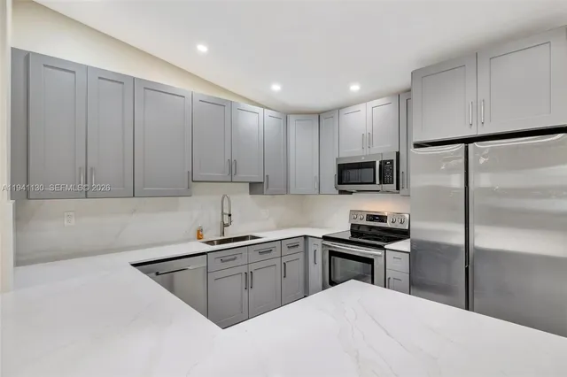 a kitchen with white cabinets sink and stainless steel appliances