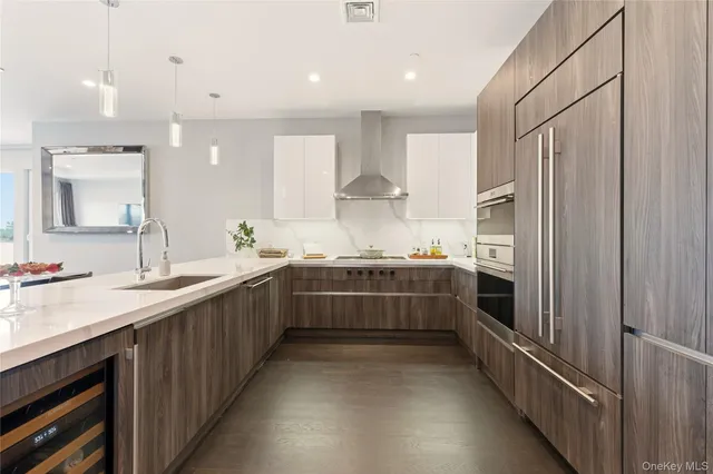 a large white kitchen with a sink and stainless steel appliances