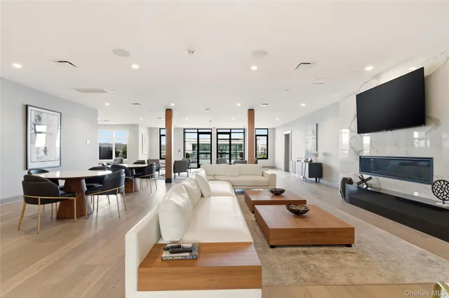 a living room with stainless steel appliances furniture and a kitchen view