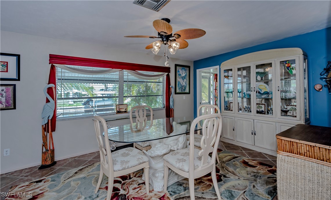 12101 Moon Shell Drive Matlacha Isles, FL 33991 - Photo 16 of 42 a dining room with furniture a chandelier and wooden floor