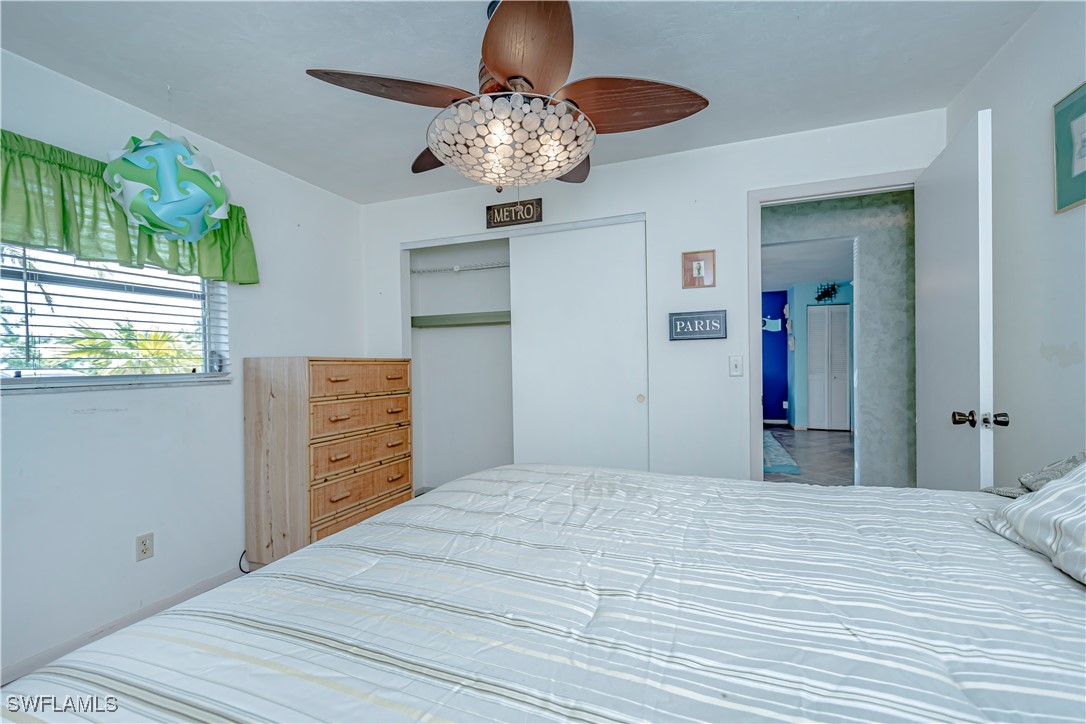 12101 Moon Shell Drive Matlacha Isles, FL 33991 - Photo 22 of 42 a bedroom with a bed and a chandelier