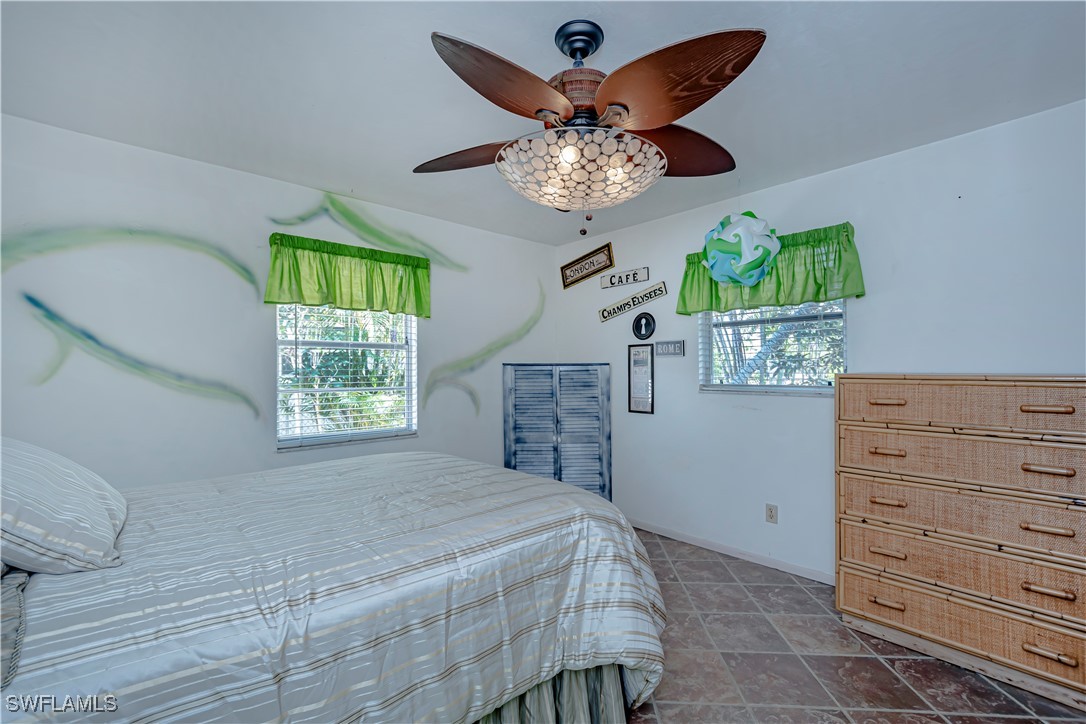 12101 Moon Shell Drive Matlacha Isles, FL 33991 - Photo 23 of 42 a bedroom with a bed and a chandelier