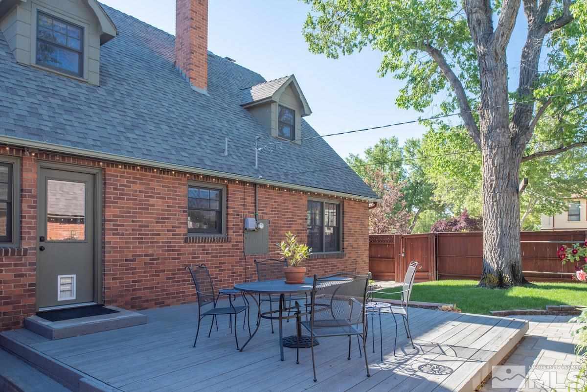 895 Lander Street Reno, NV 89509 - Photo 23 of 38 a view of a patio with table and chairs and a barbeque with wooden fence and floor