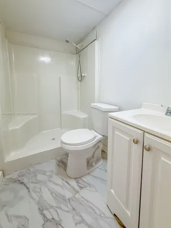 a white toilet sitting next to a bath tub