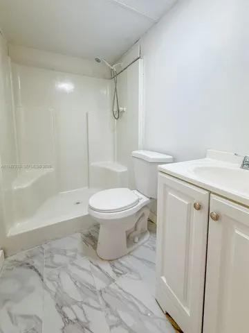 a white toilet sitting next to a bath tub